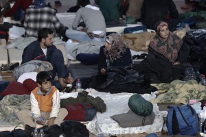 Immigrants who arrived on a cargo ship from Turkey sit on their bedding on the floor of a basketball arena where they have been given temporary shelter in the town of Ierapetra, on the southern Greek island of Crete on Friday, Nov. 28, 2014. Nearly 600 men, women and children, mostly refugees from Syria, have been temporarily put up in the southern Cretan town of Ierapetra, where they arrived in a crippled smuggling ship after more than a week at sea. (AP Photo/Petros Giannakouris)